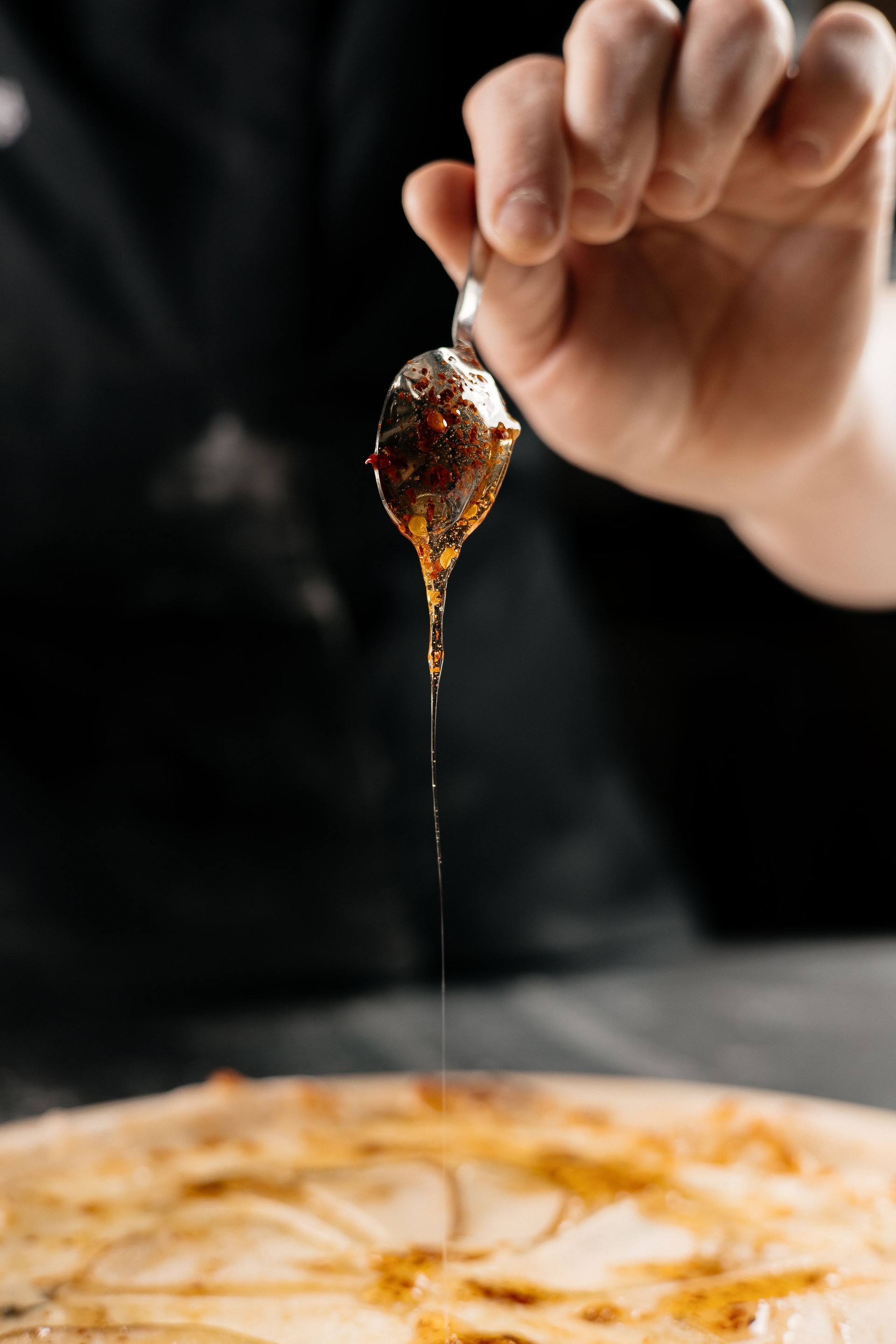 Drizzling Spicy Honey Over Pizza