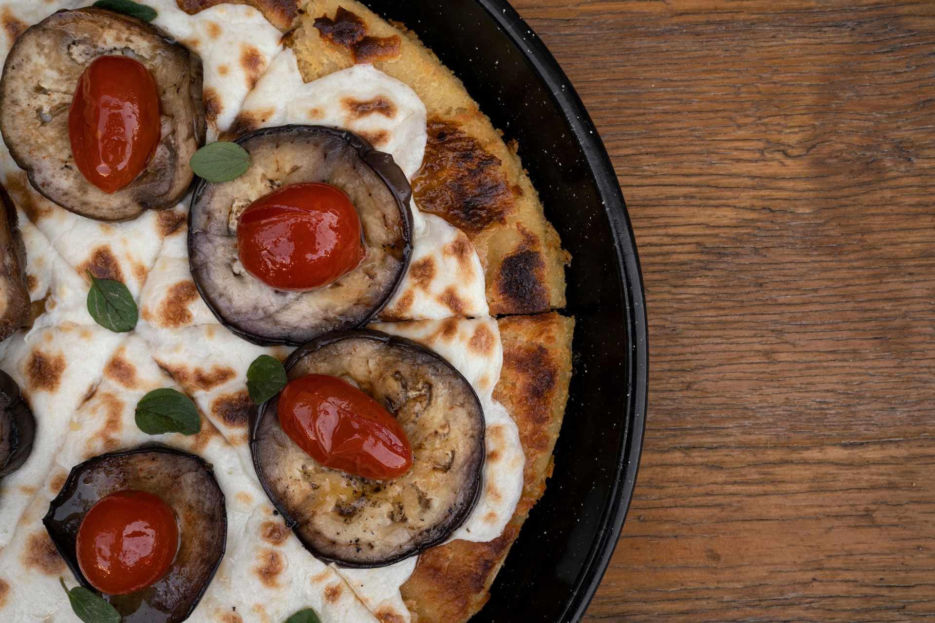 Top view of a gourmet vegan pizza with a rustic wooden background