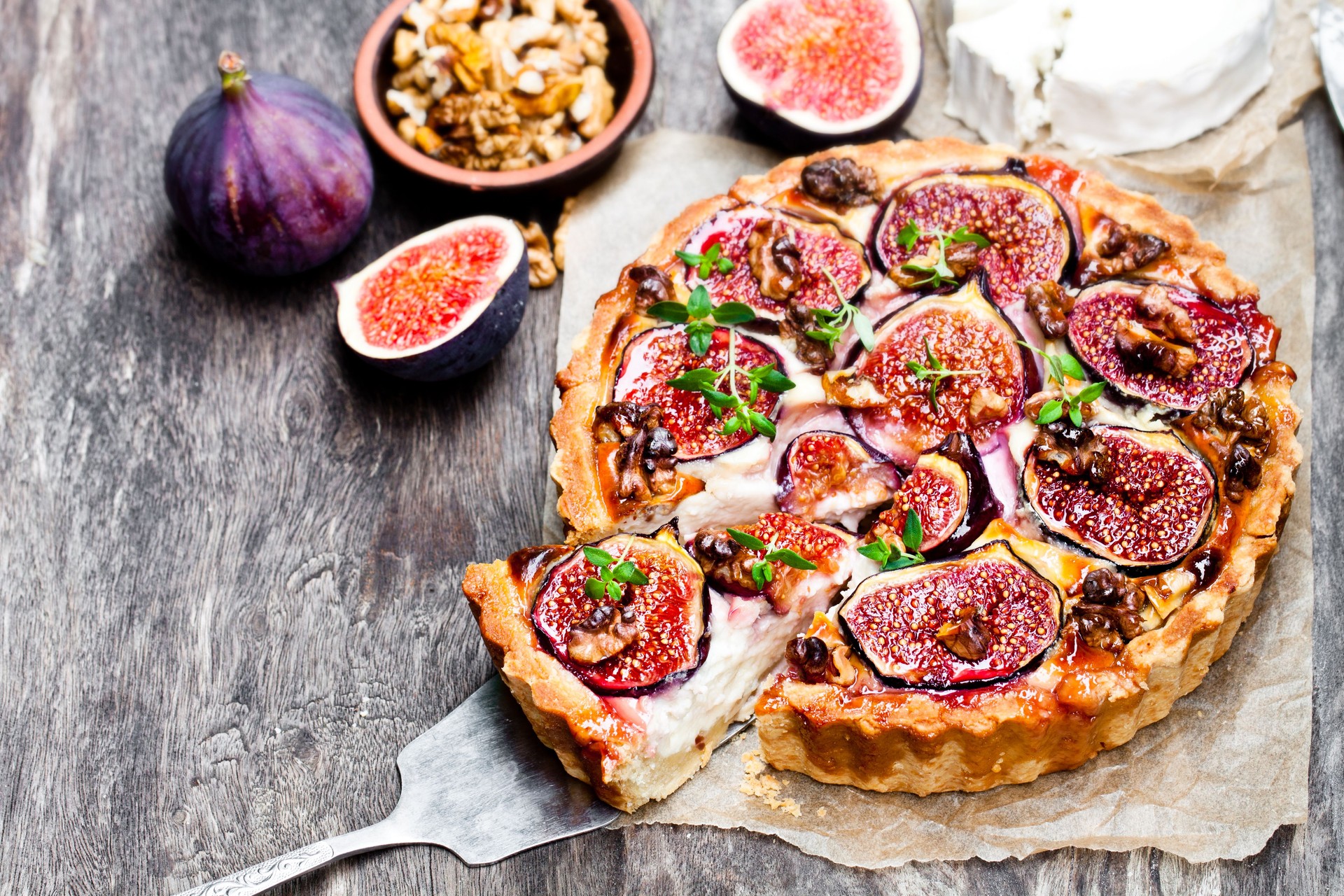 Delicious  tart with fresh figs and goat cheese on rustic wooden table