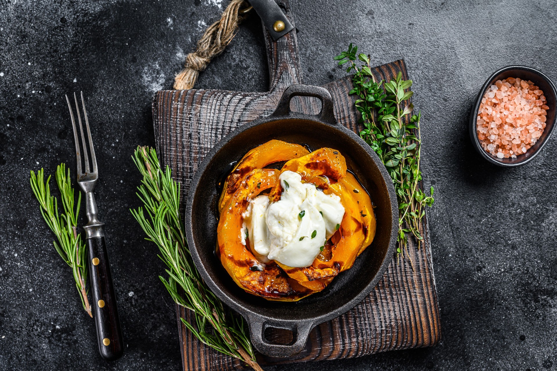 Cheese mozzarella Burrata and baked pumpkin salad. Black background. Top view