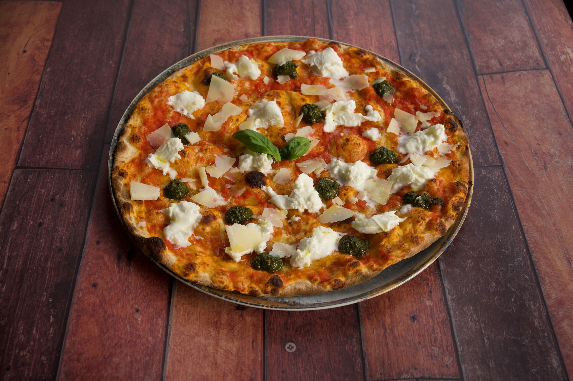 A pizza with cheese and basil on top