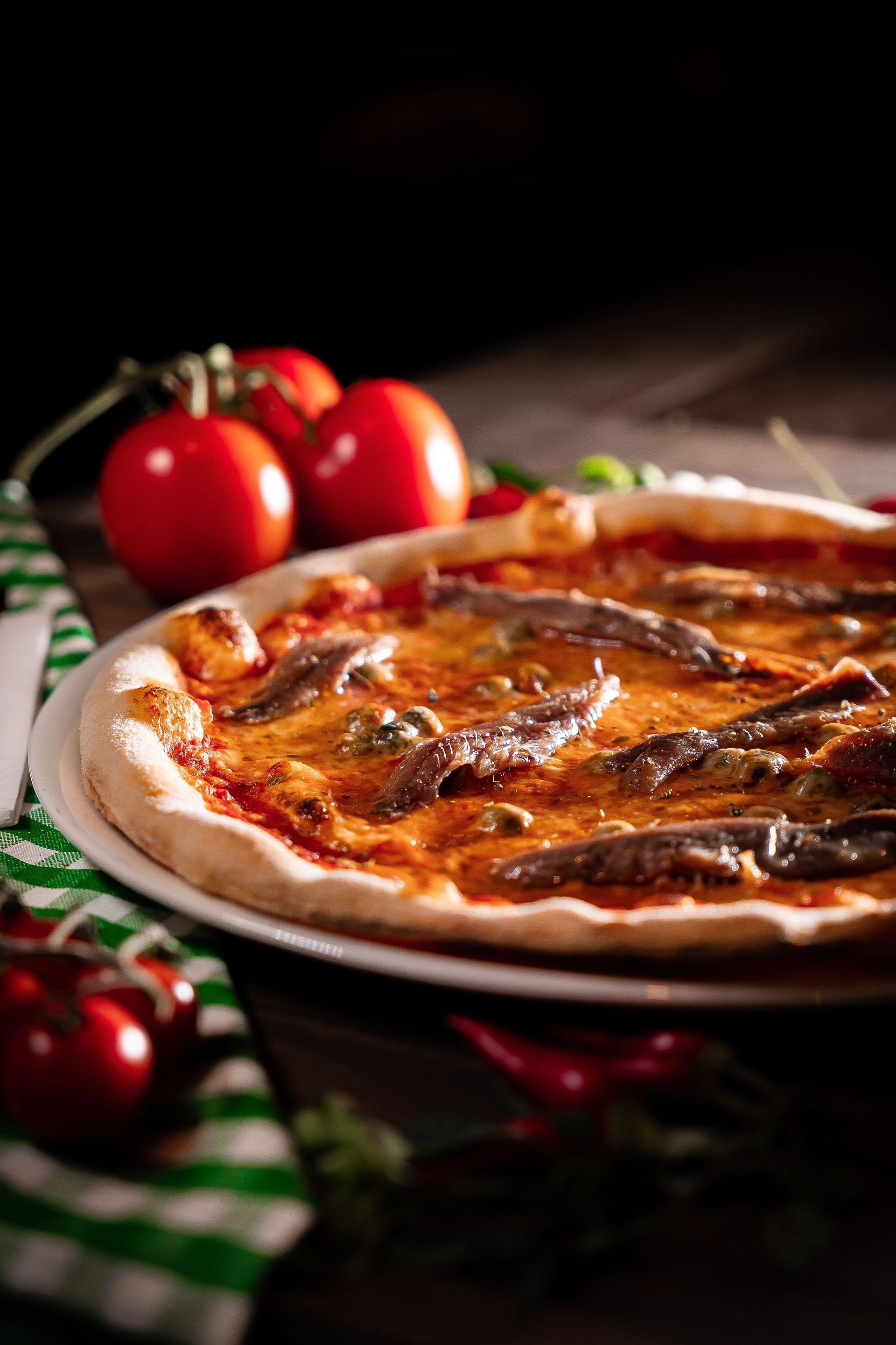 neapolitan pizza with tomatoes anchovies capers close up wooden table